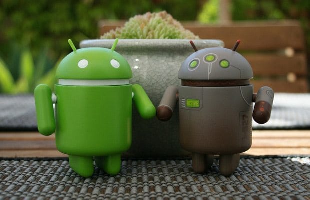 two android action figures outside on a table